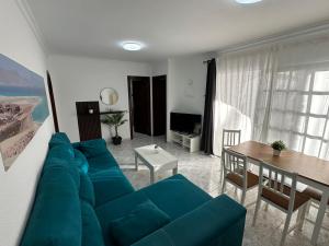 a living room with a blue couch and a table at Santa Úrsula 21 in Costa Calma