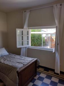 a bedroom with a bed and a large window at Casa La Cumbre in La Cumbre