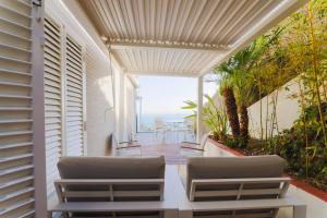 - une terrasse couverte avec 2 chaises et une vue sur l'océan dans l'établissement Sitges Suites B, à Sitges