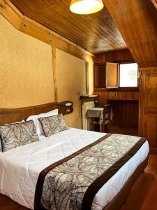 ein Schlafzimmer mit einem großen Bett in einer Hütte in der Unterkunft Hotel Togo Monte Terminillo in Monte Terminillo