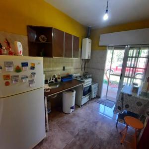 a kitchen with a white refrigerator and a sink at El sueño de papá in Santa María