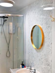 a bathroom with a shower and a sink and a mirror at Vibrant comfort (Suitable for Contractors,ShortStays and LongStays) in Portsmouth