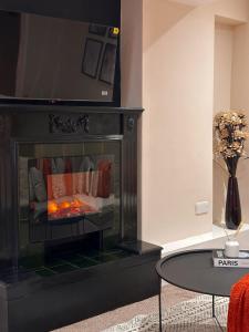 a fireplace in a living room with a fire at Vibrant comfort (Suitable for Contractors,ShortStays and LongStays) in Portsmouth