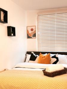 a bedroom with a bed with orange and black pillows at Vibrant comfort (Suitable for Contractors,ShortStays and LongStays) in Portsmouth