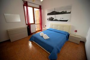 una camera con un letto blu e una finestra di Vivi Salento - Scala di Furno Porto Cesareo a Porto Cesareo