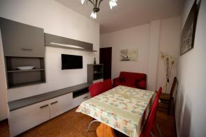 una sala da pranzo con tavolo e TV in una stanza di Vivi Salento - Scala di Furno Porto Cesareo a Porto Cesareo