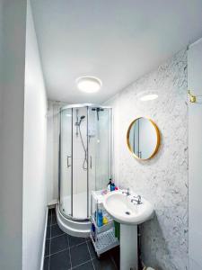 La salle de bains est pourvue d'une douche et d'un lavabo. dans l'établissement Vibrant comfort (Suitable for Contractors,ShortStays and LongStays), à Portsmouth