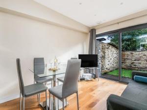 a living room with a table and chairs and a tv at Pass the Keys Ealing Queen of the Suburbs 2BD Apartment in London