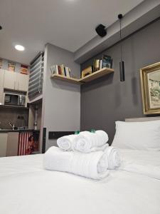 un mucchio di asciugamani seduti sopra un letto di DIONE Luxury Business Suite in the heart of Athens ad Atene