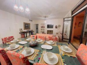 a dining room with a table with plates and chairs at Appartement cosy et calme avec jardin et piscine in Marrakech