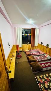a room with a row of beds on the floor at Jumanji homestay in Nagar