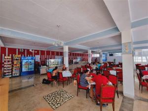 a group of people sitting at tables in a restaurant at Excelsior in Eforie Sud