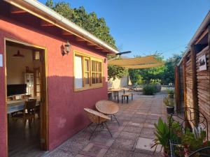 patio con tavolo, sedie e ombrellone di Scorpius Hostel a Vicuña