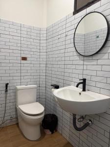 a bathroom with a sink and a toilet and a mirror at The 10 club hostel in Thongsala