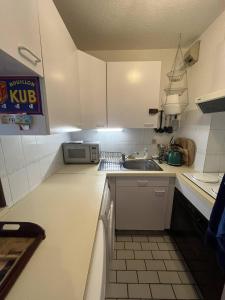 勒圖凱－巴黎普拉日的住宿－Atlante15，小厨房配有白色橱柜和水槽