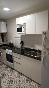 cocina con armarios blancos, fregadero y microondas en Apartment City Center Recoleta en Buenos Aires
