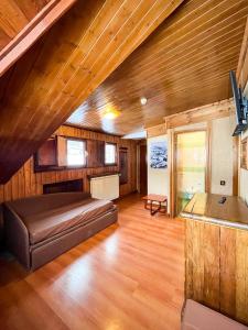Großes Zimmer mit einem Bett und einer Holzdecke. in der Unterkunft Hotel Togo Monte Terminillo in Monte Terminillo