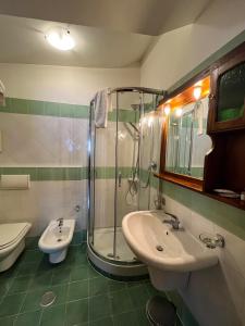 een badkamer met een douche, een wastafel en een toilet bij Hotel Togo Monte Terminillo in Terminillo