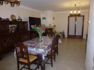 a dining room table with a vase of flowers on it at Chambre d'hôtes La Pinede in Lambesc