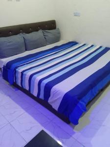 Una cama azul y blanca en una habitación en JEFFOSA Hotel & Suites, en Lagos