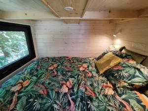 a bed in the corner of a tiny house at La mini maison du Lama in Libin