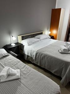 two beds in a hotel room with towels on them at Appartamenti Scilla Paese Albergo in Scilla