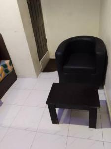 a black chair and a coffee table in a room at JEFFOSA Hotel & Suites in Lagos