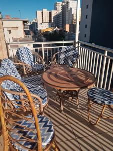 een groep stoelen en een tafel op een balkon bij DOROTHY Apartamento Playa de Gandia con vistas al mar 8 personas in Gandía