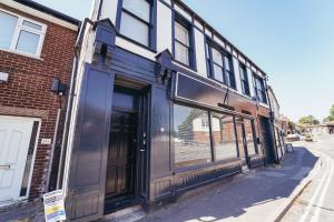 a building with glass doors on the side of a street at Cottages in Derbyshire - Duffield Apartment in Duffield