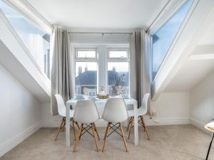 a dining room with a table and chairs in front of a window at Cosy Coastal Apartment in Whitley Bay