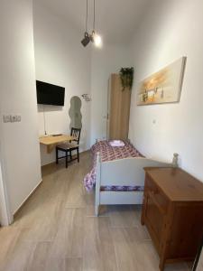 Schlafzimmer mit einem Bett, einem Schreibtisch und einem TV in der Unterkunft Azure Studio in Athen