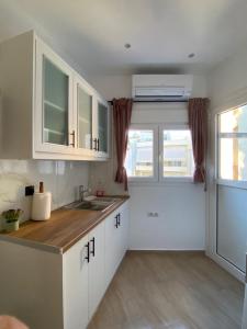 eine Küche mit weißen Schränken und einem Waschbecken in der Unterkunft Azure Studio in Athen