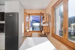 a kitchen with a refrigerator and a window at Villa Carrasca l Sea View l Pool l BBQ l ChillOut by Turyhost in Arenys de Munt