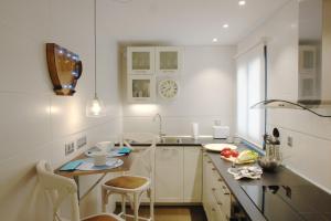 kuchnia z białymi szafkami oraz stołem i krzesłami w obiekcie Tranquilo y Céntrico apartamento 1 dormitorio w Maladze