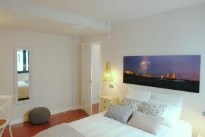sypialnia z białym łóżkiem i telewizorem na ścianie w obiekcie Tranquilo y Céntrico apartamento 1 dormitorio w Maladze