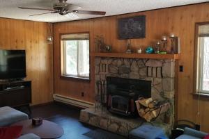 a living room with a fireplace and a tv at Mountain Life On Deck in Arnold