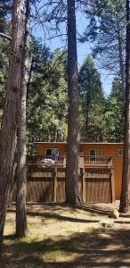 a fence with trees in front of a house at Mountain Life On Deck in Arnold
