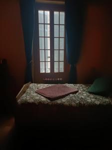 Schlafzimmer mit einem Bett, einem Fenster und einem Tisch in der Unterkunft À l'étape des jeunes randonneurs un adulte un enfant in Saignon