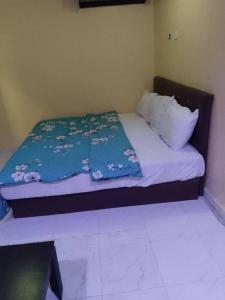 JEFFOSA Hotel & Suites في لاغوس: غرفة نوم مع سرير مع لحاف ووسائد زرقاء