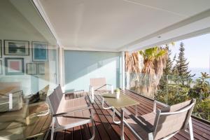 een kamer met een balkon met een tafel en stoelen bij Sitges Suites in Sitges