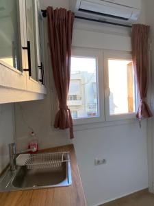 eine Küche mit einem Waschbecken und einem Fenster in der Unterkunft Azure Studio in Athen
