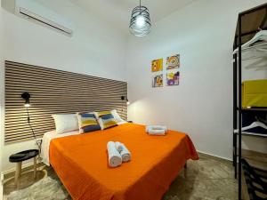 a bedroom with a bed with orange sheets and towels at La Dimora di Anna e Ciccio in Casteldaccia