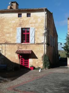 Studio i Languedoc. في Nézignan-lʼÉvêque: مبنى به نافذة حمراء وقطة في الأمام