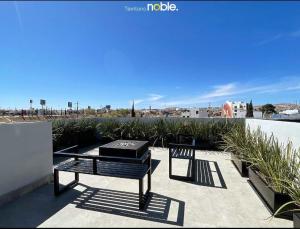 um pátio com uma mesa e um banco no telhado em Reluciente departamento em Chihuahua