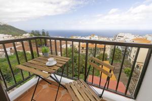 a balcony with a wooden bench and a view of the ocean at Central Apartment 2-min walking to city center, Professional Coffee Machine, Fully Equiped Kitchen in Icod de los Vinos