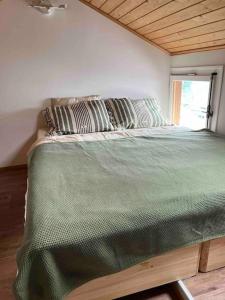 un letto con piumone verde in una camera di Bijou Loft - Charming Loft on Lake Thun near Interlaken a Merligen