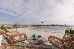 a balcony with a table and chairs and a beach at Ran de Mar - First Line Studio in Alcudia