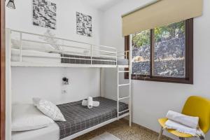 een slaapkamer met een stapelbed en een gele stoel bij Central Penthouse, close to the Natural pools with Big terrace, ocean & city view in Garachico