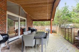 a patio with a table and chairs on a patio at Large Cottage In Peaceful, Beautiful Nature in Mølby