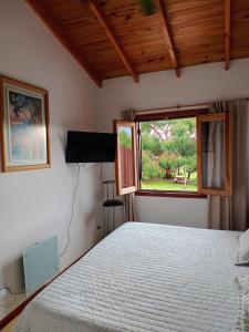 1 dormitorio con cama y ventana en Casa Bordó, B & B en Tandil